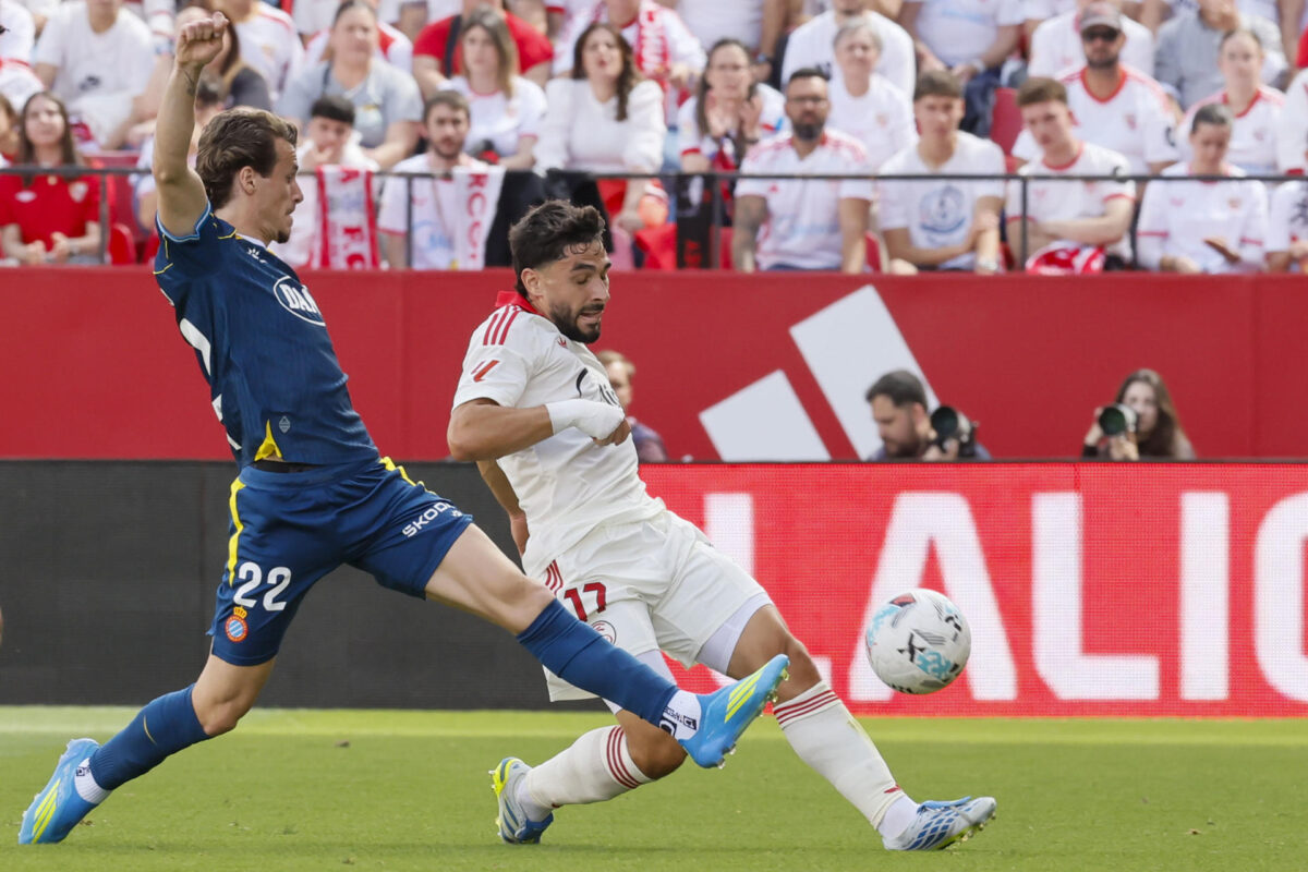 El delantero francés del Sevilla Neal Maupay (d) pelea un balón con el defensa del Espanyol Carlos Romero durante el partido de LaLiga entre el Sevilla y el Espanyol, este sábado en el estadio Sanchez Pizjuan de Sevilla. EFE/José Manuel Vidal