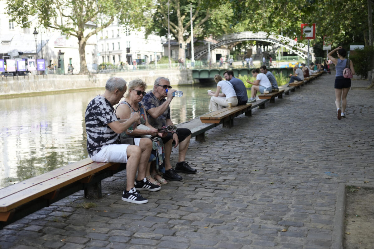Varias personas descansan a orillas del Sena en París, este martes. Francia vivió este martes la madrugada más calurosa desde que empezaron los registros a nivel nacional en 1947, con una mínima de 21,6 grados de media, que superó el anterior récord de 21,4 grados del 25 de julio de 2019, indicó Météo France. EFE/ Edgar Sapiña