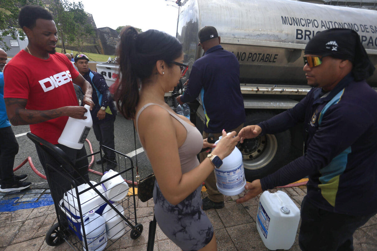Personas se abastecen de agua tras la interrupción del servicio este lunes, en San Juan (Puerto Rico). EFE/Thais Llorca