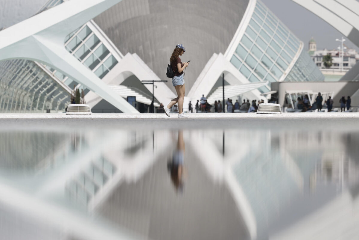 Una joven se refleja en el estanque de la Ciudad de las Artes y las Ciencias de Valencia este lunes. EFE/ Kai Försterling
