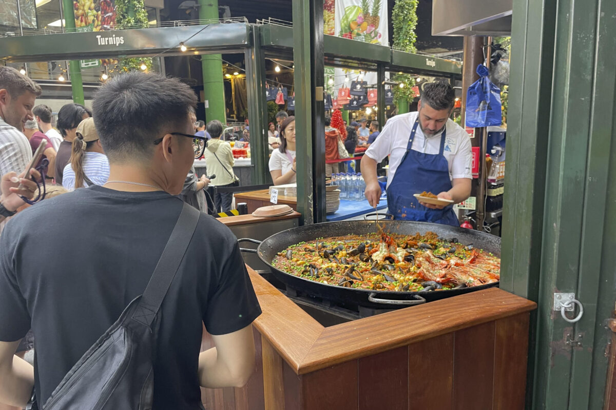 El mercado gastronómico de Borough, uno de los más populares de Londres, recibe a diario largas colas de visitantes para comprar una porción de paella en el puesto de arroces que causa furor entre los turistas y visitantes y donde se venden más de 1.000 raciones a diario. Son las diez de la mañana y huele a aceite de oliva, ajo, cebolla, pimiento y tomate rallado, el tradicional sofrito de paella. También se escucha cómo las cucharas rascan el fondo de la paellera para obtener el característico'socarrat'. Esta escena podría ser la típica imagen, salvando la hora, en cualquier restaurante, bar o calle del Mediterráneo español. Sin embargo, el lugar es el mercado gastronómico de Borough en Londres.-EFE/ Luis Campello