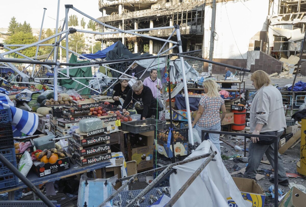 Kiev (Ucrania), 19/07/2026.- Residentes limpian y recogen la comida de un mercado afectado por un ataque con misiles rusos en Kiev. EFE/EPA/SERGEY DOLZHENKO