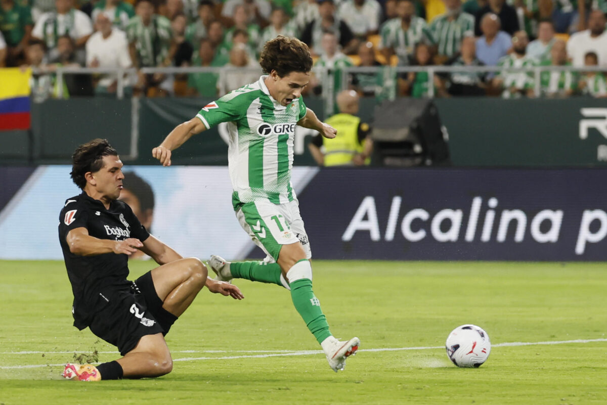 El centrocampista del Betis Rodrigo Riquelme (d) pelea un balón con el defensa de la Real Sociedad Jon Aramburu durante el partido de LaLiga de fútbol que Real Betis y Real Sociedad disputan este viernes en el estadio de La Cartuja, en Sevilla. EFE/Jose Manuel Vidal