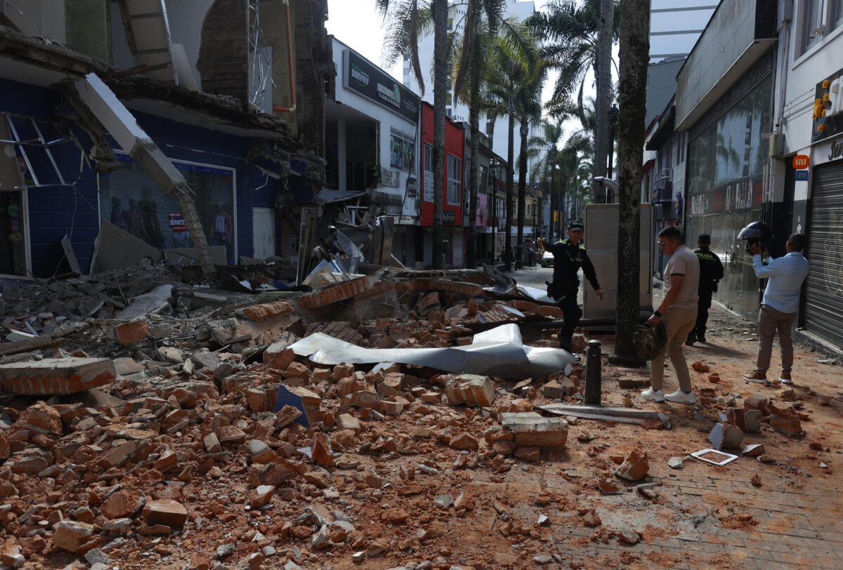 Un grupo de personas fue captado este 10 de agosto al caminar sobre los escombros de una edificación afectada en Manizales (Colombia), tras el un fuerte terremoto de magnitud 7,4 que sacudió buena parte del país suramericano. EFE/John Jairo Bonilla