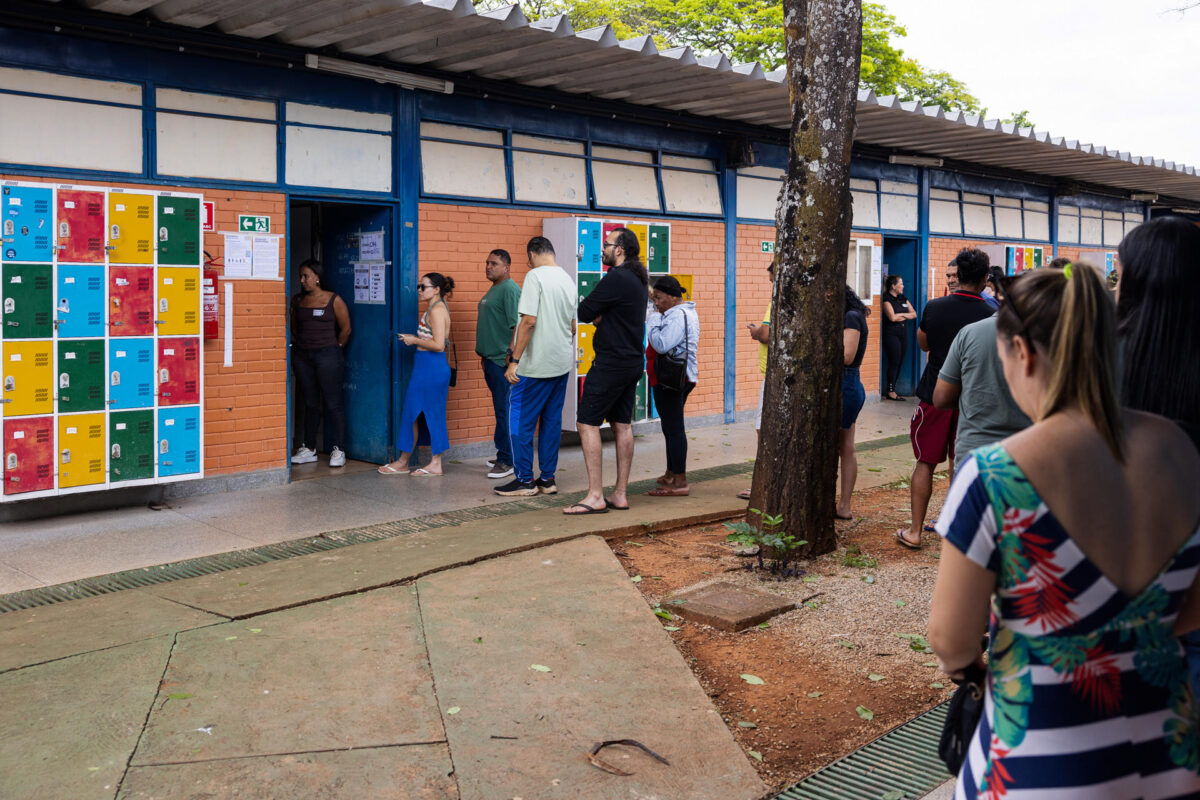 Personas esperan en un puesto de votación este domingo, durante las elecciones presidenciales, legislativas y regionales, en las que el actual mandatario, Luiz Inácio Lula da Silva, busca la reelección frente a su principal rival, el senador Flávio Bolsonaro, en Brasilia (Brasil). EFE/ Vinícius Santa Rosa