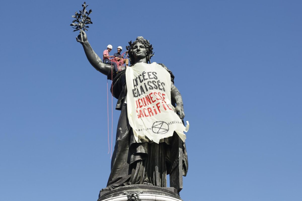 Unos manifestantes trepan a una estatua para colgar una pancarta con el lema Generación de alumnos abandonada y sacrificada durante una jornada nacional de protestas por las condiciones escolares, protagonizada por estudiantes y miembros de sindicatos educativos, en la plaza de la República de París (Francia), este martes. EFE/EPA/MOHAMMED BADRA